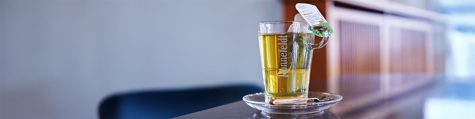 Glastasse mit Teebeutel auf Bürotisch