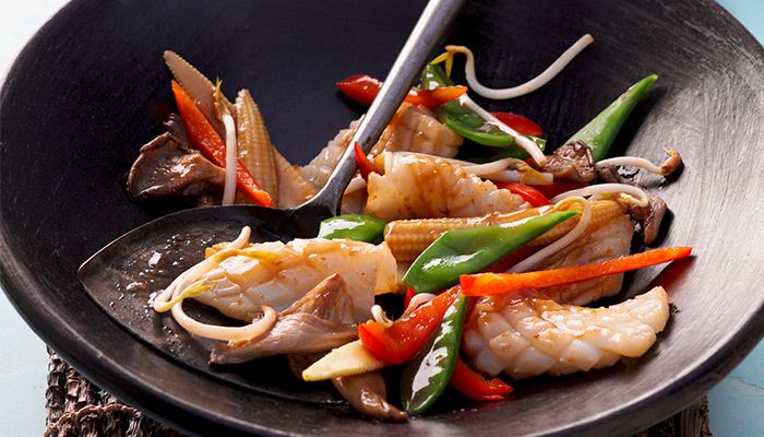 Asiatische Wok-Pfanne mit Tintenfisch, Zuckerschoten, Paprika, Pilzen, Babymais und Sojasprossen