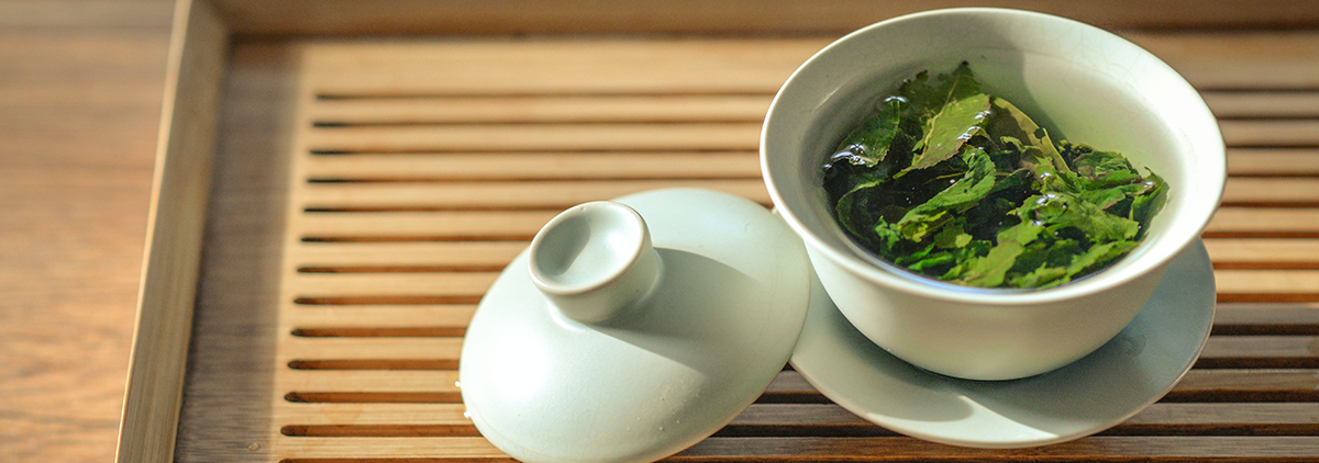 Frisch aufgebrühter grüner Tee in einer Gaiwan-Schale